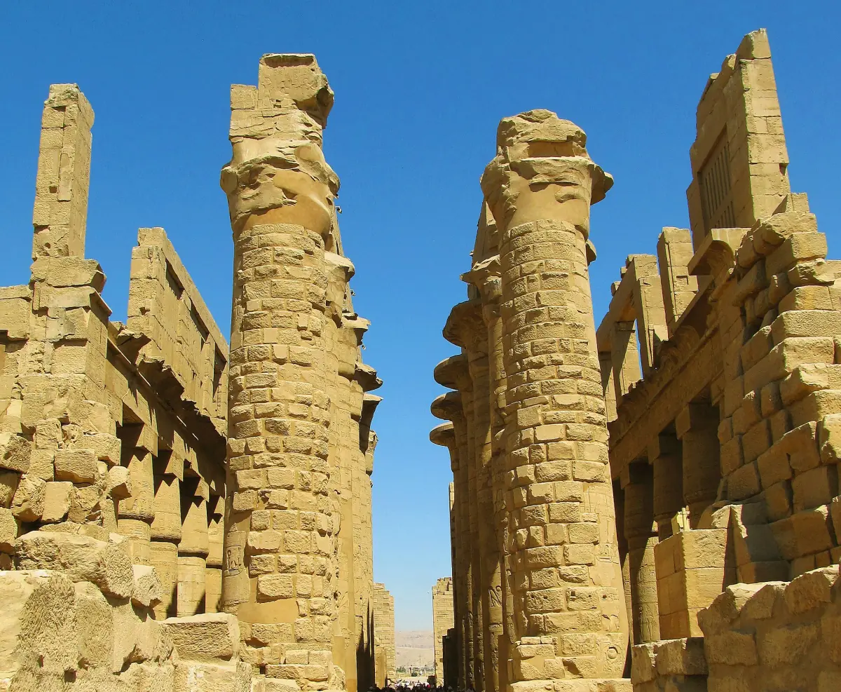 Tall carved columns of the Great Hypostyle Hall rising into a blue sky