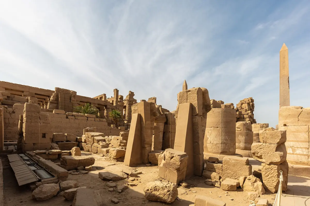 Obelisk rising above the ruins and columns inside the Karnak precinct