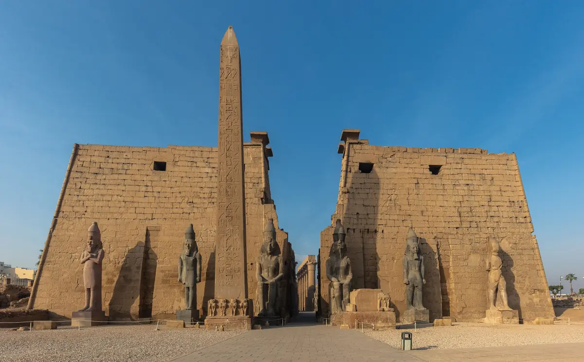 Luxor Temple entrance with obelisk between two pylon towers in daylight